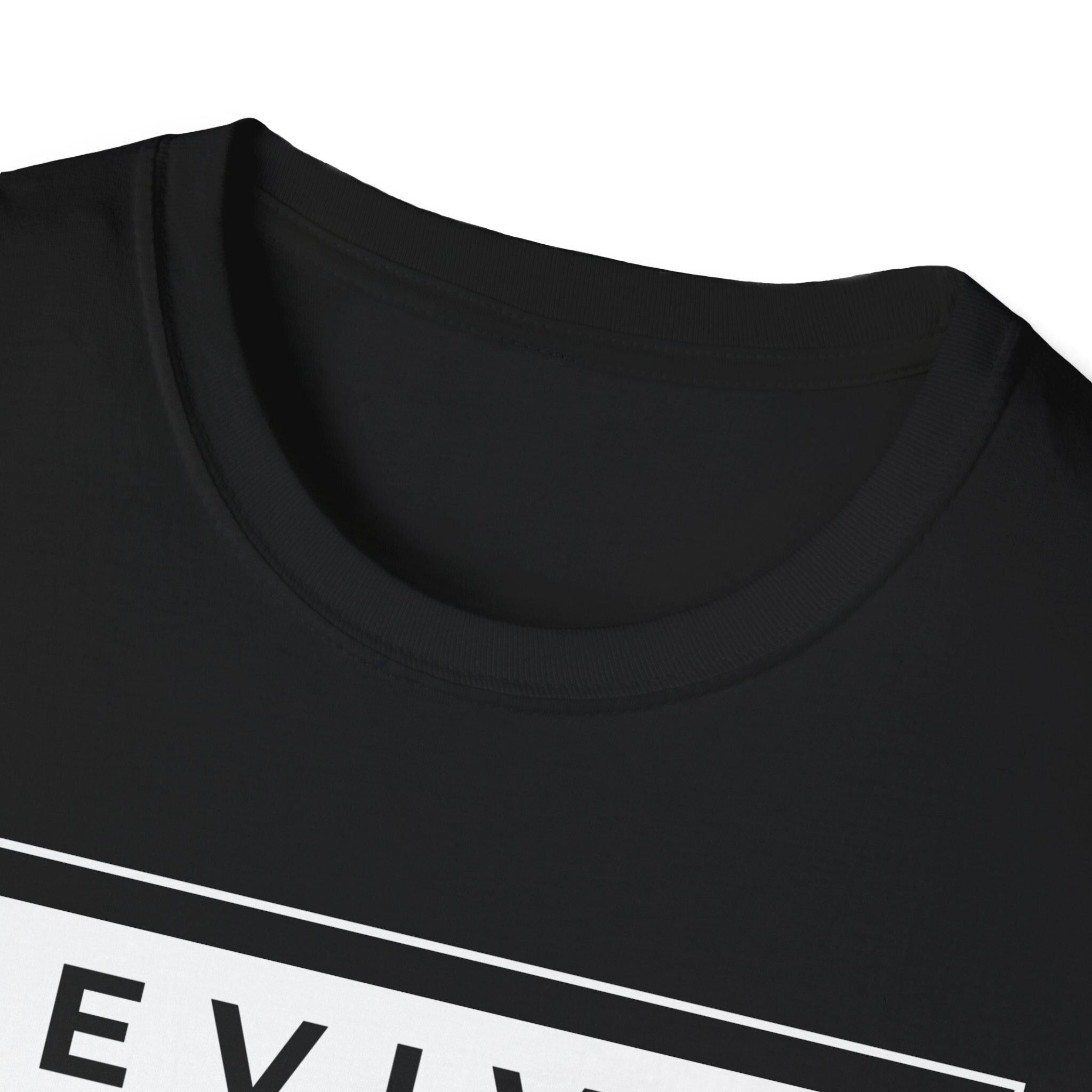 May include: A black t-shirt with a white rectangular box on the bottom that says 'REVIVE'. The t-shirt has a crew neck.